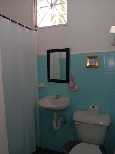 a bathroom with a sink and a toilet and a mirror at Casa Tzipora in Brisas de Zicatela