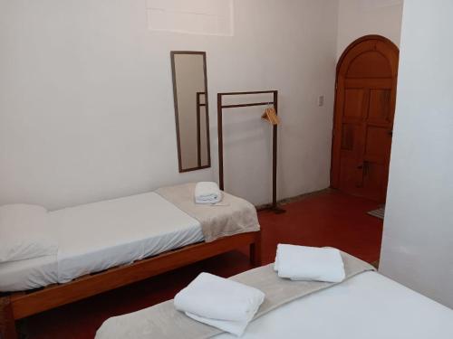 a room with two beds and a mirror and a door at Casa Tzipora in Brisas de Zicatela