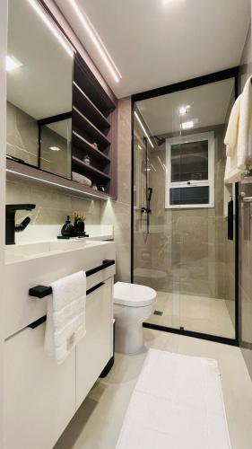 a bathroom with a toilet and a glass shower at Studio home office Inteligente Com Alexa no Coração do Shopping in Mogi das Cruzes