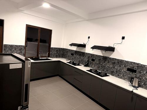 a kitchen with black and white counter tops at Pearl Diamond Resort in Trincomalee