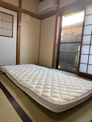 a large mattress in a room with a window at あかねや in Marugame