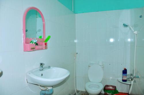 La salle de bains est pourvue d'un lavabo, de toilettes et d'un miroir. dans l'établissement Hai Anh Guesthouse, à Duong Dong