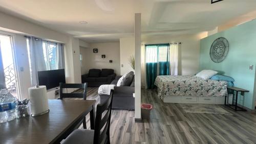 a living room and a bedroom with a bed and a table at Casa Axhé Rosarito in Rosarito Beach