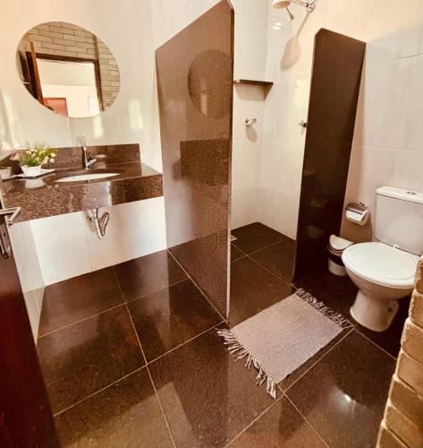 a bathroom with a toilet and a sink and a mirror at Pousada e Flat Royal 04 in Itapecerica