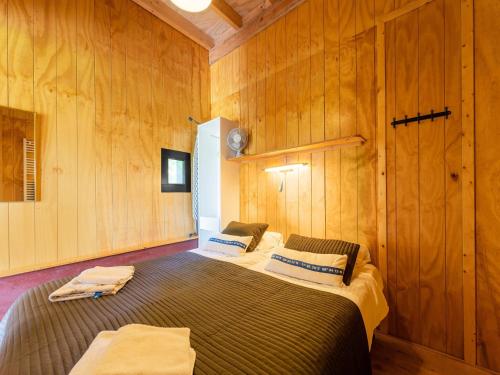 two beds in a room with wooden walls at Cottage in Dwingelderveld with Scenic Views in Beilen