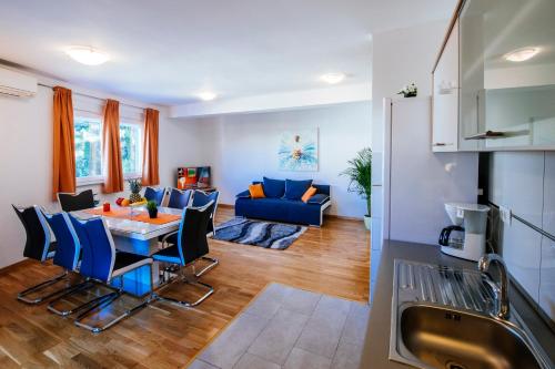 salon ze stołem i niebieską kanapą w obiekcie Rainbow apartments w mieście Zadar