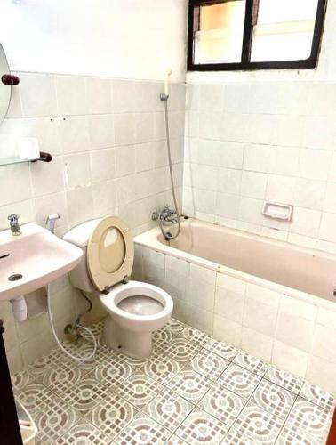 a bathroom with a toilet and a sink and a tub at Kencana INN in Bandungan
