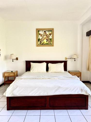a bedroom with a large bed with white sheets at Kencana INN in Bandungan