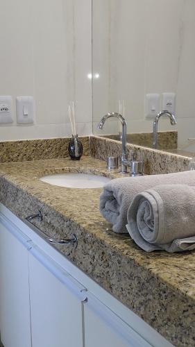 a bathroom counter with a sink and a towel at Tropical Executive Suite Flat 1001 Veiw in Manaus