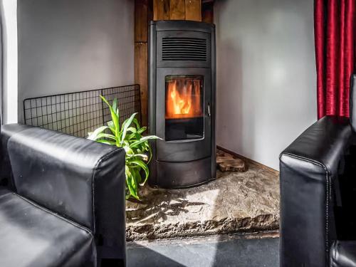 a fireplace in a living room with two leather chairs at The Bunkhouse - Uk50470 in Greenhaugh