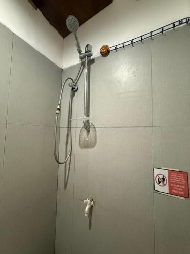a shower with a shower head in a bathroom at Couple Room by Burication Homestay in General Luna