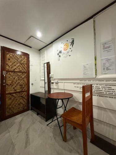 a room with a table and a chair and a wall at Couple Room by Burication Homestay in General Luna