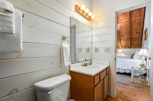 a bathroom with a sink and a toilet and a bed at Kingfisher's Cabin 15 Minutes to Casino Hot tub Firepit in Murphy