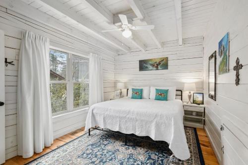 a white bedroom with a bed and a window at Kingfisher's Cabin 15 Minutes to Casino Hot tub Firepit in Murphy