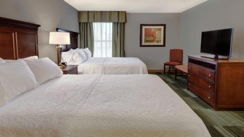 a hotel room with two beds and a flat screen tv at Inn On The Parkway Pigeon Forge in Pigeon Forge