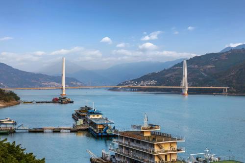 a large river with boats and a bridge at PORTAL ART HOTEL in Fengjie