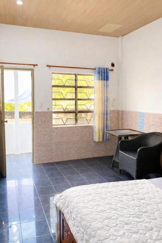 a bedroom with a bed and a table and a window at Thanh Bình Motel Bến Tre in Ben Tre
