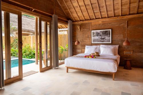 a bedroom with a bed with a teddy bear on it at Taman Jati in Gili Islands