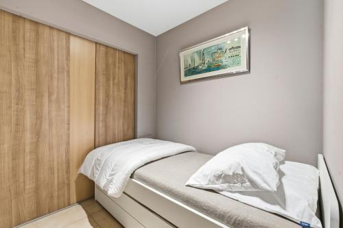a small bedroom with a bed with white sheets at Walter Vilain 0301 G in Sint-Idesbald