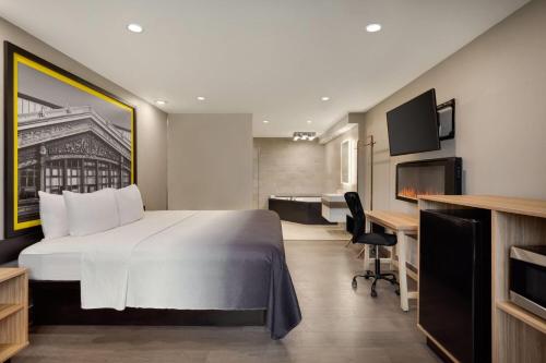 a hotel room with a large bed and a desk at Super 8 by Wyndham Meadowlands in Carlstadt