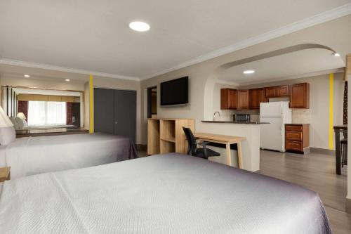 a hotel room with two beds and a kitchen at Super 8 by Wyndham Meadowlands in Carlstadt