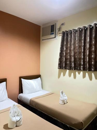 two beds in a room with shoes sitting on them at Olive Suites in Cagayan de Oro
