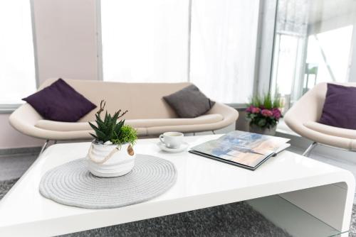 a living room with a white coffee table with a plant at elaya hotel wolfenbuettel, Trademark Collection by Wyndham in Wolfenbüttel