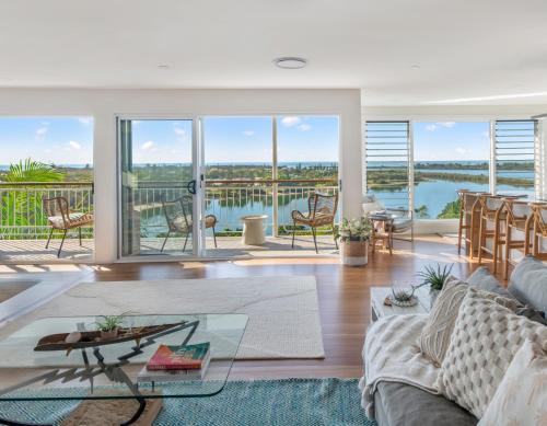 a living room with a couch and a view of the water at THE PENTHOUSE - Spectacular Views of the Bay, and the Ocean! Only 150m to Shaws Bay in East Ballina