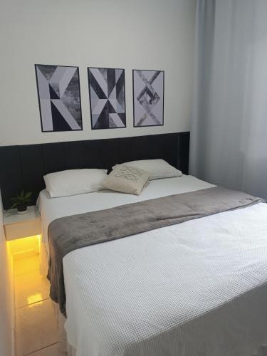 a bed in a bedroom with two pillows on it at Apartamento 2QTS aconchegante in Vila Velha