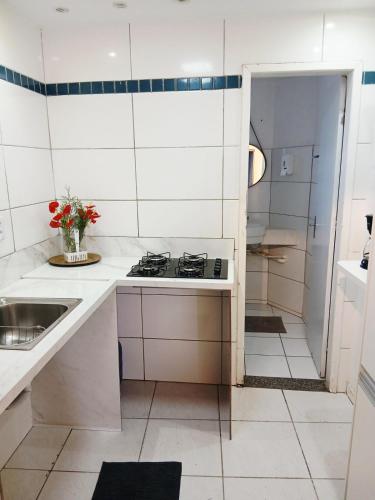 a white kitchen with a stove and a sink at Apartamento 2QTS aconchegante in Vila Velha