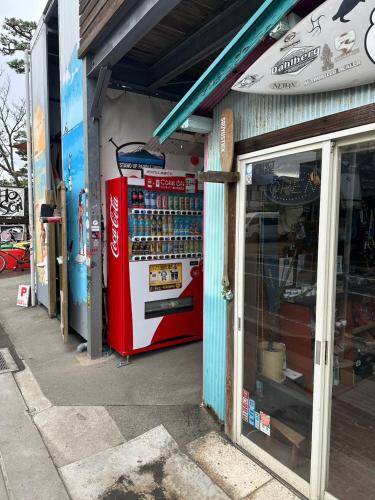 a soda machine sitting outside of a store at Guest Room Chigasaki in Chigasaki