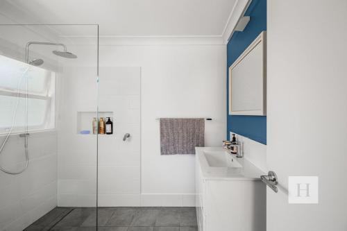 a bathroom with a sink and a shower at Garden Cottage Noraville in Toukley