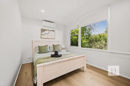 a bedroom with a bed and a window at Sunset Shore Retreat in Summerland Point