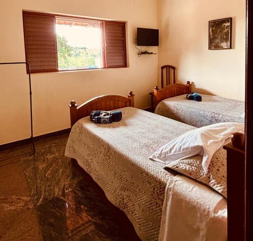 a room with two beds and a window at Pousada Flat Royal - Flat 03 in Itapecerica
