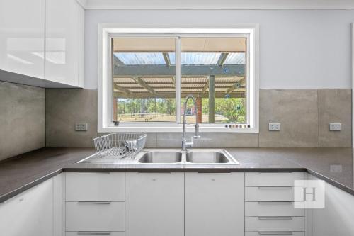 a kitchen with a sink and a window at Jilliby Honey Farm in Jilliby