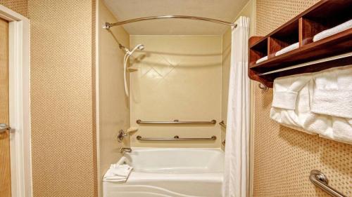 a bathroom with a tub and a sink and towels at Inn On The Parkway Pigeon Forge in Pigeon Forge