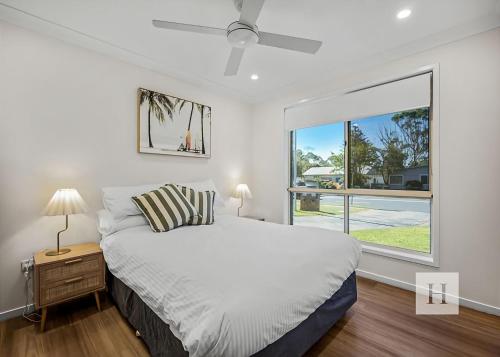 a bedroom with a bed and a large window at Pete's Retreat -500m from the beach in Norah