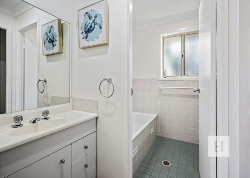 a white bathroom with a tub and a sink and a shower at Pete's Retreat -500m from the beach in Norah
