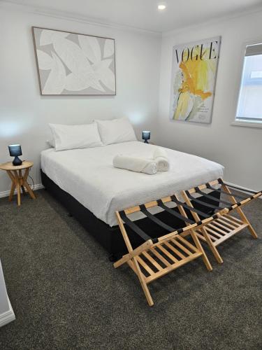 a bedroom with a large bed with a wooden frame at Redwood Apartments in Rotorua