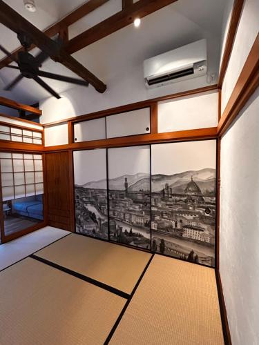 a room with a painting of a city on the wall at Locanda L`altra Cucina in Yokosuka