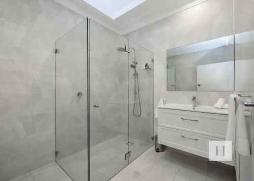 a bathroom with a glass shower and a sink at Angels Little Haven in Cams Wharf