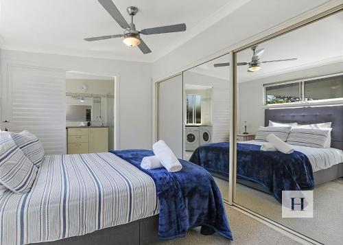 a bedroom with two beds and a ceiling fan at Karinyah in Summerland Point