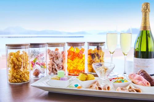 a tray with a bottle of wine and some food and glasses at Hotel Den Haag Huis Ten Bosch in Sasebo
