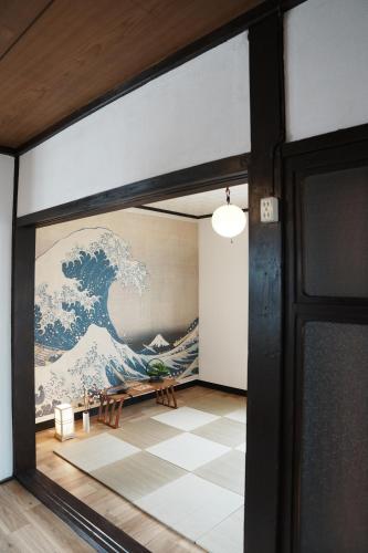 a mural of the great wave on the wall in a room at 8人宿泊可 子供添い寝無料 1日1組限定で開放感のある90平米 吉野山天川村40分 奈良大阪1時間 駅から徒歩5分 家主居住型 大淀桜庵 in Oyodo