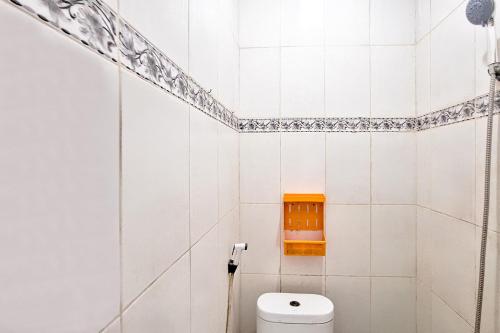 a bathroom with a toilet and a shelf on the wall at Villa Citra Syariah RedPartner in Kalibata 1