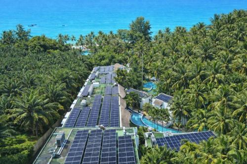 an aerial view of a resort with solar panels and the ocean at Eden Beach Khao Lak Resort & Spa in Khao Lak