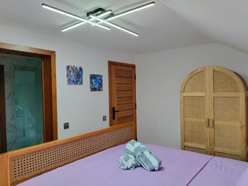 a bedroom with a purple bed with a ceiling fan at Villa Claudine in Ambengan