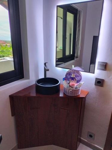 a bathroom with a sink and a mirror at Villa Claudine in Ambengan