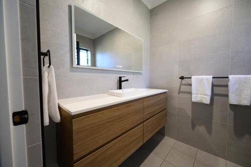 a bathroom with a sink and a mirror at Old Maitland Inn - Rutherford in Maitland