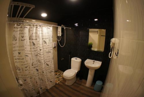 a bathroom with a toilet and a shower curtain at X Rector Finest in Tioman Island